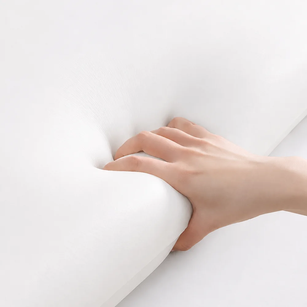 Premium hotel room with a carefully layered bed, pillows, and soft hospitality fabrics
